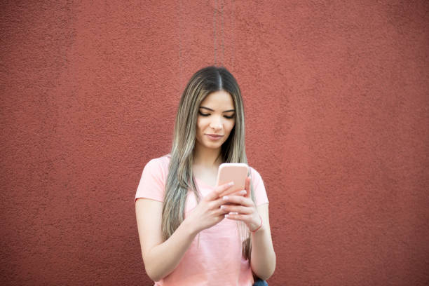 istock A young beautiful woman uses a smartphone outside 1386537006