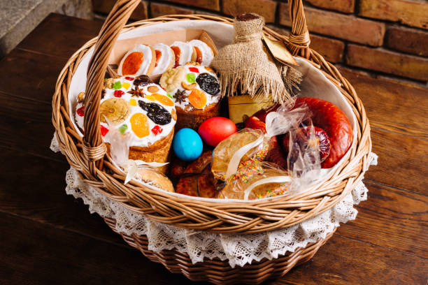 Easter basket with ukrainian easter cake, cookies and Easter eggs on a wooden desk. stock photo