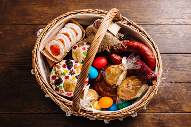 Easter basket with ukrainian easter cake, cookies, sausage and Easter eggs on a wooden desk. Orthodox Easter stock photo