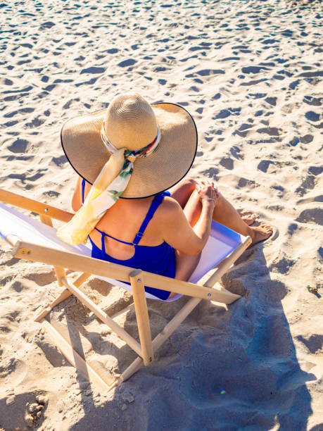 istock Woman relaxing on beach sitting on sunbed 1386543796