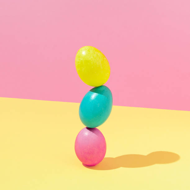 istock Colorful Easter eggs composition against vibrant yellow and pink background. Minimal Easter concept. Creative fun spring holiday food idea. 1386551305