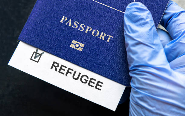 istock Refugee passport in hand at border control in Europe 1386567072