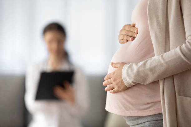 nahaufnahme der frau, die ein baby erwartet, das einen termin beim arzt hat - human pregnancy midwife visit healthcare and medicine stock-fotos und bilder