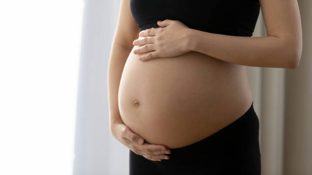 futura mãe segurando as duas mãos em barriga grávida nua e pesada - abdómen - fotografias e filmes do acervo