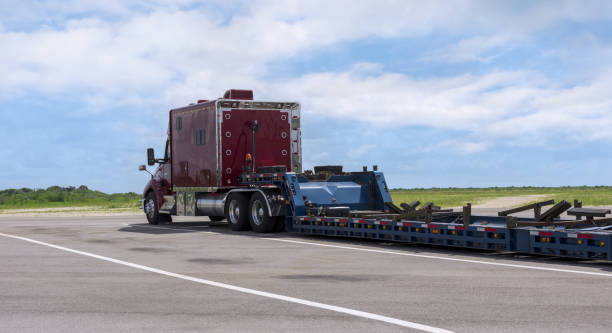 red semi-truck with empty flatbed trailer