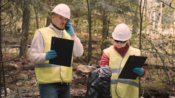 istock Man, woman environmentalists document offense - forest pollution and issue fine 1386577764