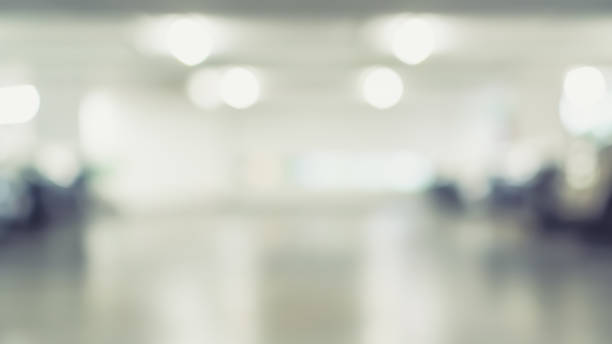 istock Parking garage blur background with blurry building interior lot space and bright illumination light bokeh for automotive vehicle and car insurance safety concept 1386577843