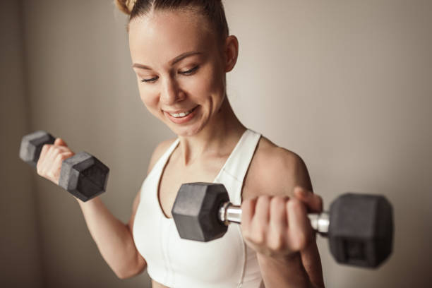istock Strong female athlete exercising with dumbbells 1386577944