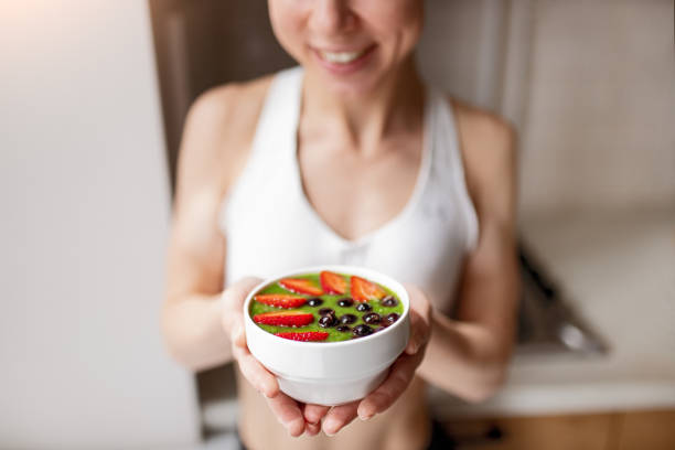istock Happy woman with healthy breakfast bowl 1386577962