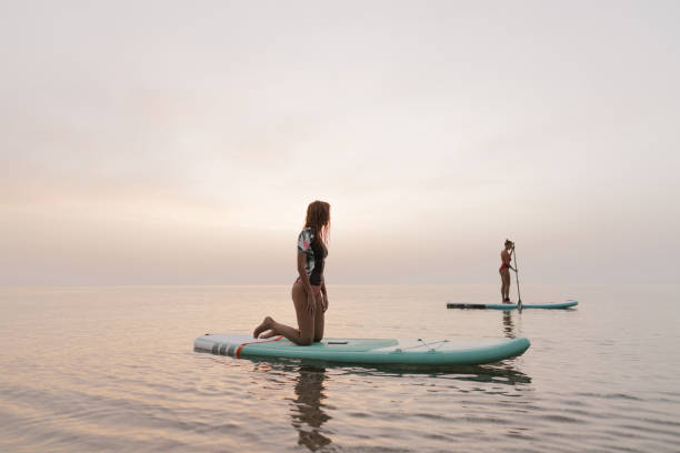 istock Girlfriends stand-up paddling together 1386580521
