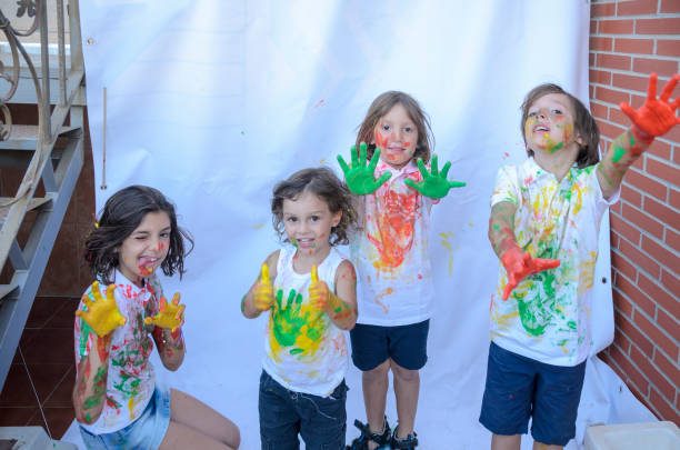 istock Kids playing with paint and getting stained, lot of fun. 1386584101