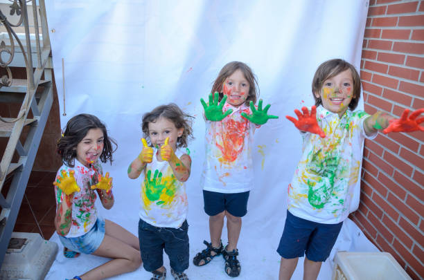 istock Kids playing with paint and getting stained, lot of fun. 1386584103