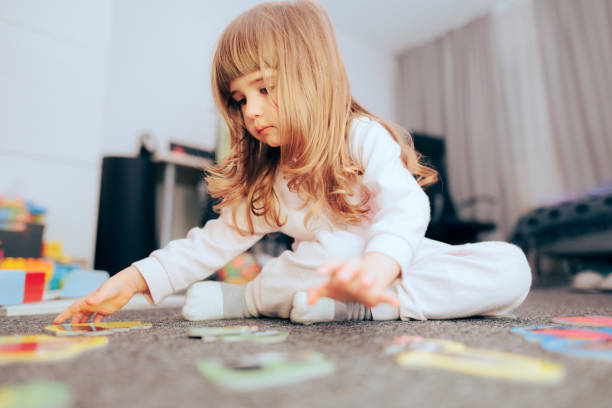 istock Little Girl Playing with a Puzzle at Home 1386602167