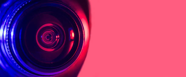 istock Camera lens with purple and red backlight. Cyberpunk style. Banner 1386605376
