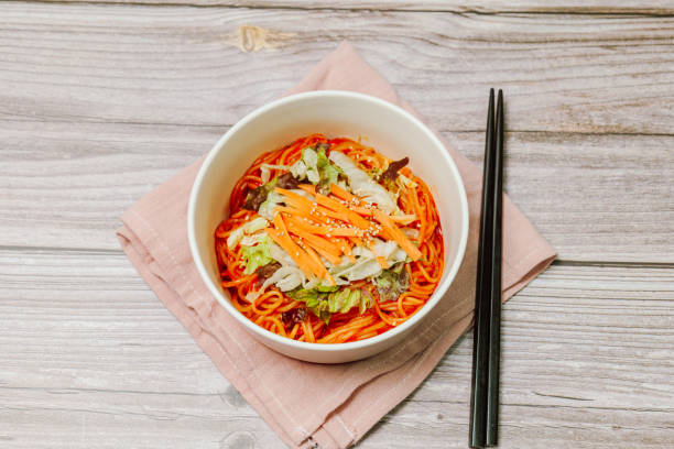 jjolmyeon fait référence aux nouilles épaisses à la farine caractérisées par leur moelleuse. il est généralement garni de concombre, de chou et de germe de haricot et mélangé à une sauce gochujang (pâte de piment rouge) à la table. - prepared shrimp skewer rice prepared fish photos et images de collection