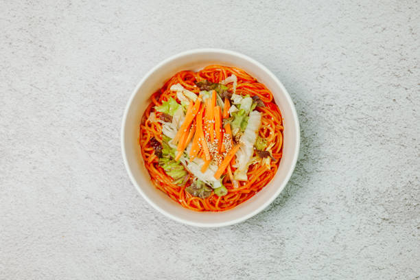 jjolmyeon fait référence aux nouilles épaisses à la farine caractérisées par leur moelleuse. il est généralement garni de concombre, de chou et de germe de haricot et mélangé à une sauce gochujang (pâte de piment rouge) à la table. - prepared shrimp skewer rice prepared fish photos et images de collection