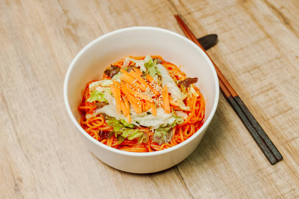 jjolmyeon se refiere a fideos de harina gruesa caracterizados por su masticabilidad. por lo general, se cubre con pepino, repollo y brotes de frijoles y se mezcla con una salsa gochujang (pasta de chile rojo) en la mesa. - prepared shrimp skewer rice prepared fish fotografías e imágenes de stock