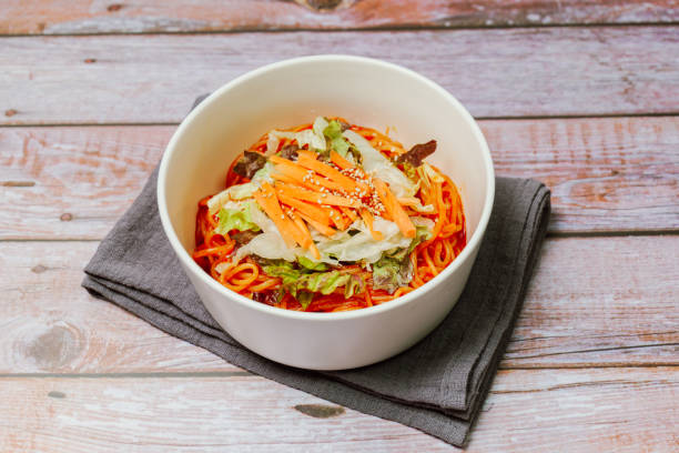 jjolmyeon fait référence aux nouilles épaisses à la farine caractérisées par leur moelleuse. il est généralement garni de concombre, de chou et de germe de haricot et mélangé à une sauce gochujang (pâte de piment rouge) à la table. - prepared shrimp skewer rice prepared fish photos et images de collection