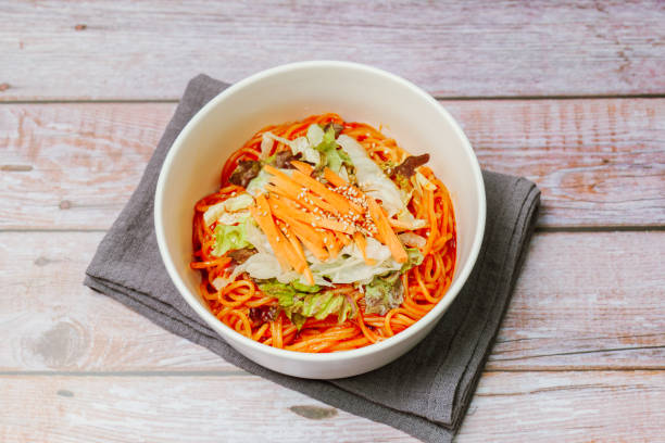 jjolmyeon fait référence aux nouilles épaisses à la farine caractérisées par leur moelleuse. il est généralement garni de concombre, de chou et de germe de haricot et mélangé à une sauce gochujang (pâte de piment rouge) à la table. - prepared shrimp skewer rice prepared fish photos et images de collection