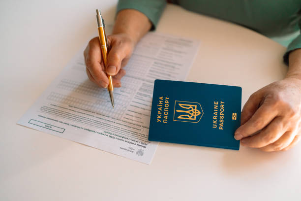 istock 50 60s Caucasian woman hand write with a pen in PESEL document on white table at state service department 1386611380