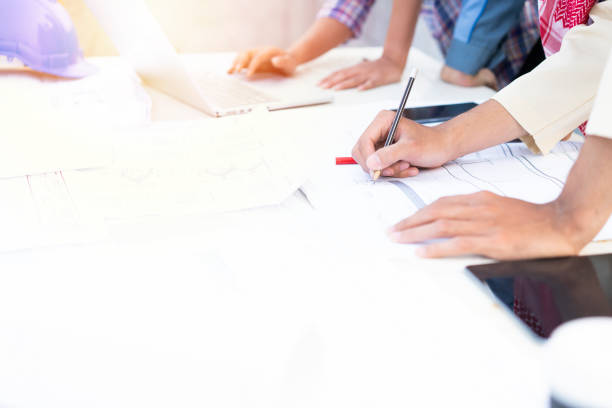 istock Engineers team were consulted together and plan in construction site, close up at hand on the table, engineering and industrial construction concept 1386615817