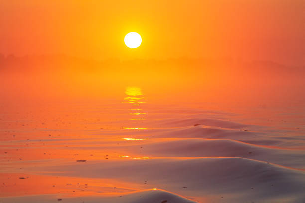 Bright rising sun in haze above waves successful frame of waves, bright colors