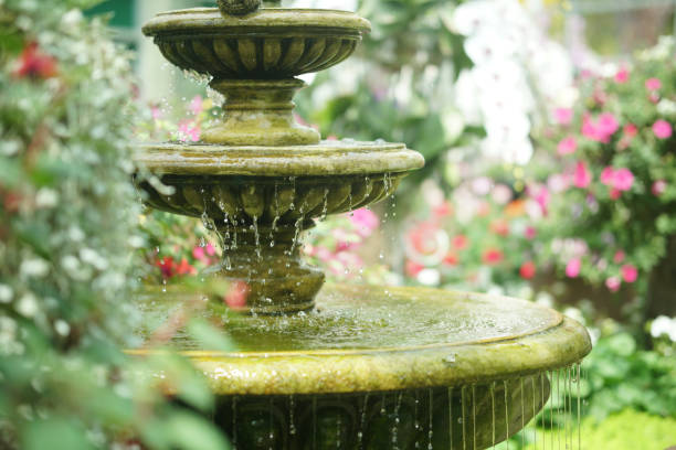 water flowing fountain decorating in garden water flowing fountain decorating in flower garden fountain stock pictures, royalty-free photos & images