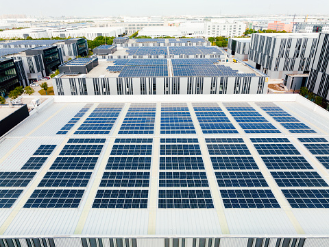 Aerial view of solar panels on factory roof.