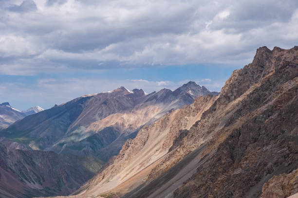istock Beautiful mountain range with cloudy sky background. Hiking, trekking concept. Landscape background. Barskoon mountain pass. 1386622314