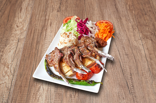 White plate with Lamb chop  and vegetables on wooden table