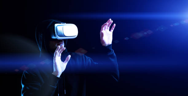 istock Vr goggles virtual reality. Young man in digital helmet for 3d virtual reality game on dark background. Study and virtual world in 3D simulation. 1386625394