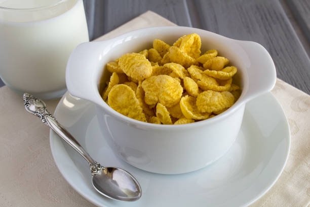 Close-up on corn flakes in the white  bowl and milk