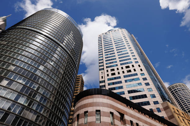 Low angle view of tall buildings with blue sky and some clouds.