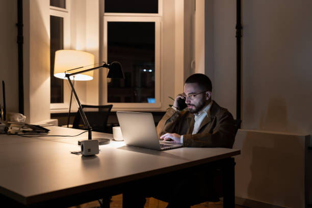 istock Young Businessman, Journalist Or Pr Manager Work At Night On New Project In Empty Coworking Space 1386629121