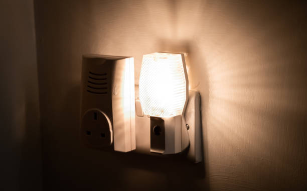 Close up of a night light plugged into a wall in a house stock photo