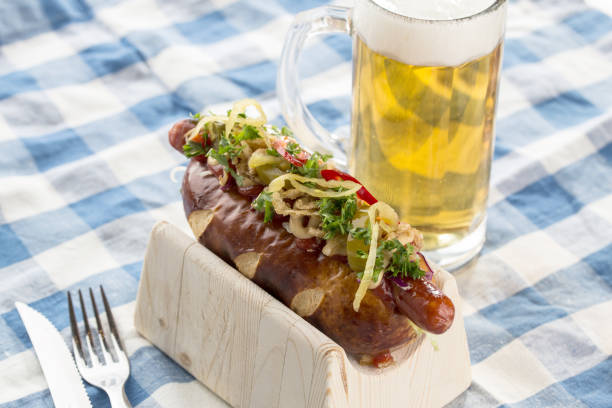 Sauerkraut sweet mustard hot dog and glass of beer on fabric napkin stock photo
