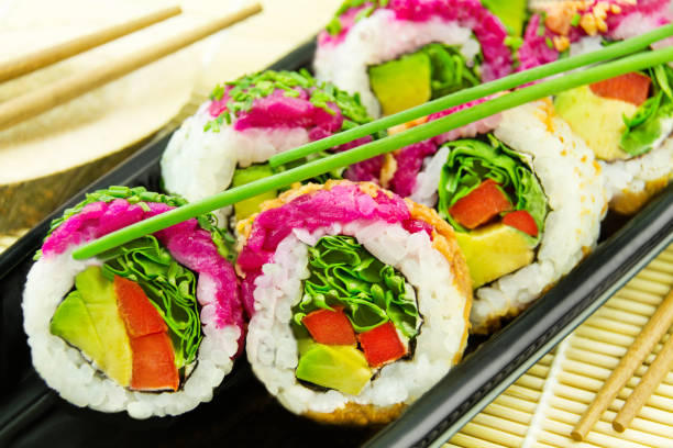 Veggy Sushi California Roll and chopsticks on bamboo background closeup