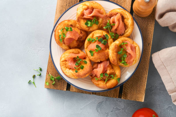 istock Yorkshire pudding. Traditional English Yorkshire pudding with salmon and radish microgreens side dish on white plate and light grey background table. Top view. 1386644840