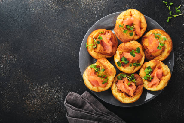 istock Yorkshire pudding. Traditional English Yorkshire pudding with salmon and radish microgreens side dish on dark grey plate and dark background table. Top view. 1386645382