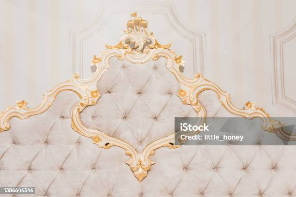 Luxury Royal Headboard Of Expensive Bed With Golden Elements And Light Beige Textile Elegant Part Of Bedroom Interior Stock Photo - Download Image Now