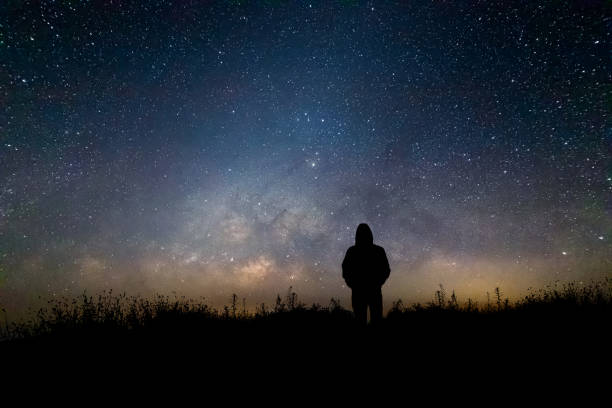 istock Silhouette man looking milky way in summer night sky 1386648163