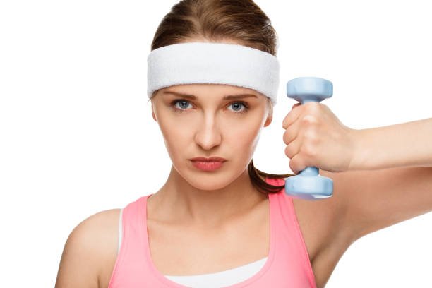 Shot of a young woman using weights against a studio background Ready to pump some iron sweat band stock pictures, royalty-free photos & images