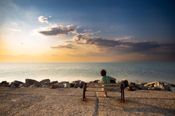 istock Sunset view by the sea with guitar musician 1386670854