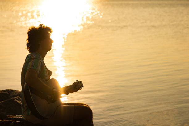 istock Young guitarist near sea 1386671268
