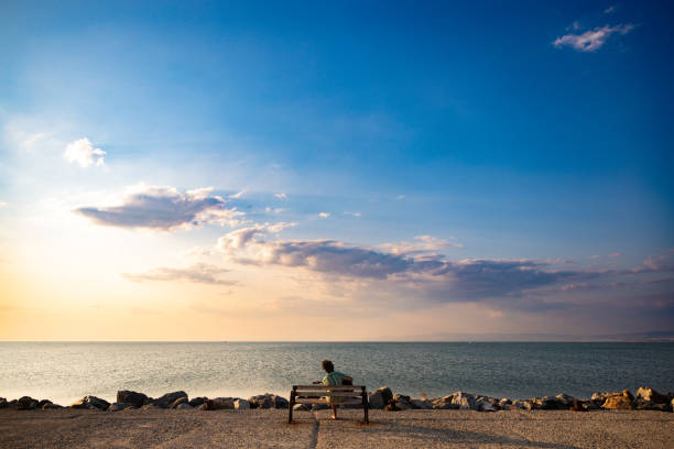 Panoramic lanscape of sunset and young man playing guitar.