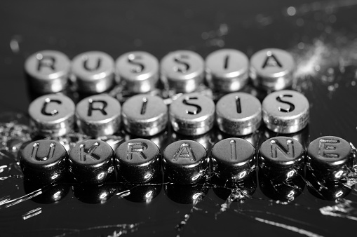 The inscription Russia, crisis, Ukraine on the background of broken glass. Black and white photo.