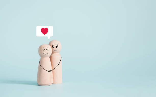 couple wooden doll happy in love with painted smiley and hugging in Valentines day concept on pastel blue background and copy space.Valentine's Day background. stock photo