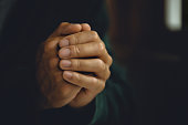 Man worship pray for god blessing to wishing have a better life. Man hands holding praying to god with the bible. christian life crisis prayer to god concept