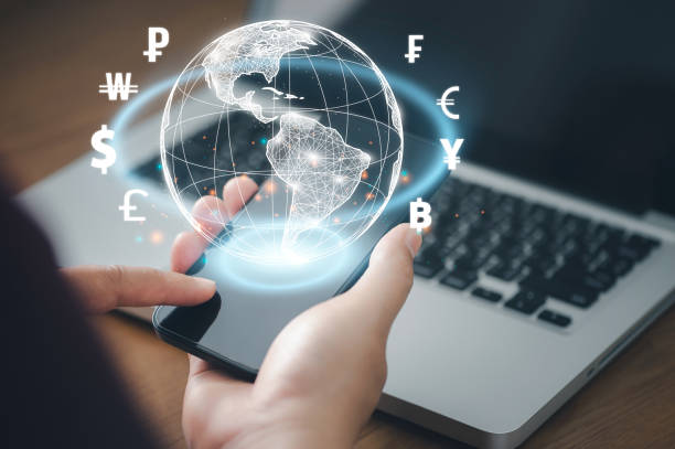 istock Man using mobile phone and laptop computer to money transfers and currency exchanges between countries of the world. online banking interbank payment concept. 1386672440