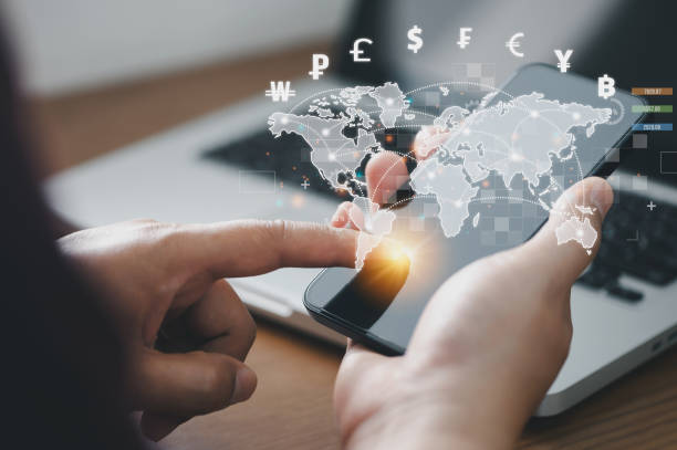 istock Man using mobile phone and laptop computer to money transfers and currency exchanges between countries of the world. online banking interbank payment concept. 1386672459